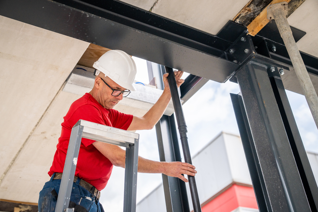 Monteur van Evelo werkt op een ladder aan een stalen constructie