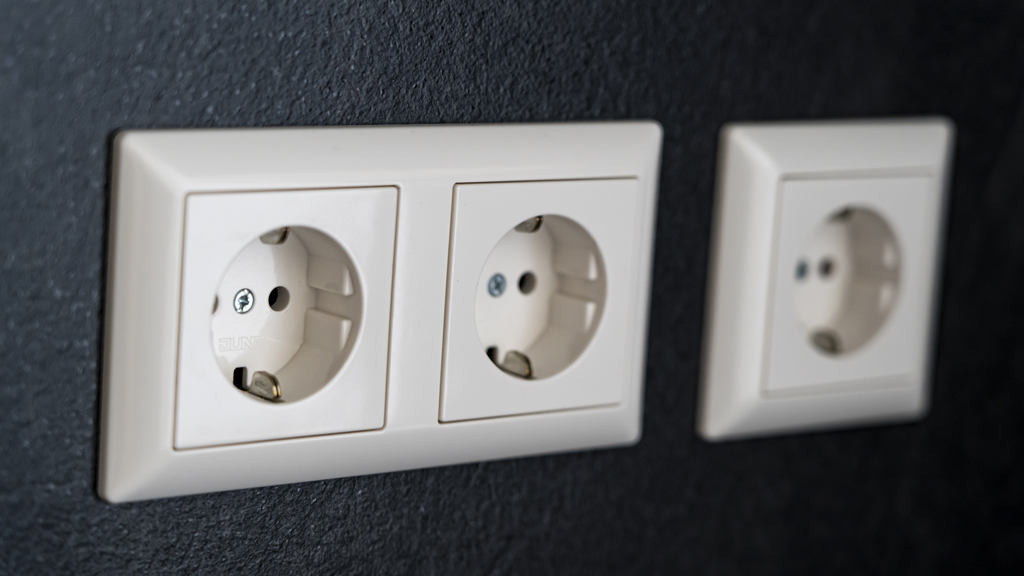 Close-up van witte stopcontacten tegen een donkere wand