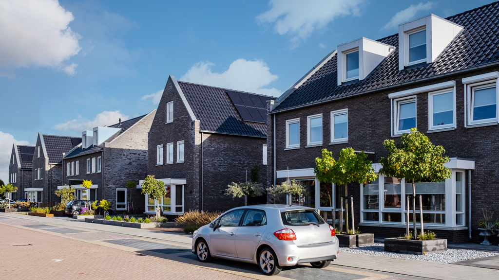 Woonhuis met zonnepanelen op het dak en auto op de oprit